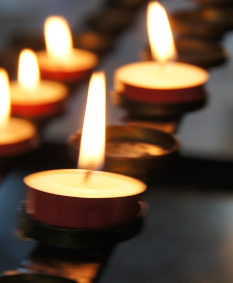 5 small candles lit in a close up shot