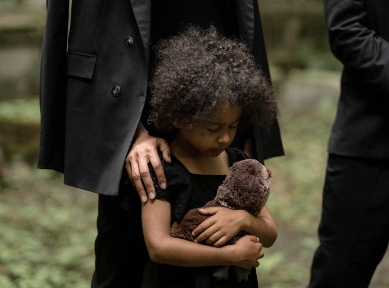A young girl grieving at a funeral.