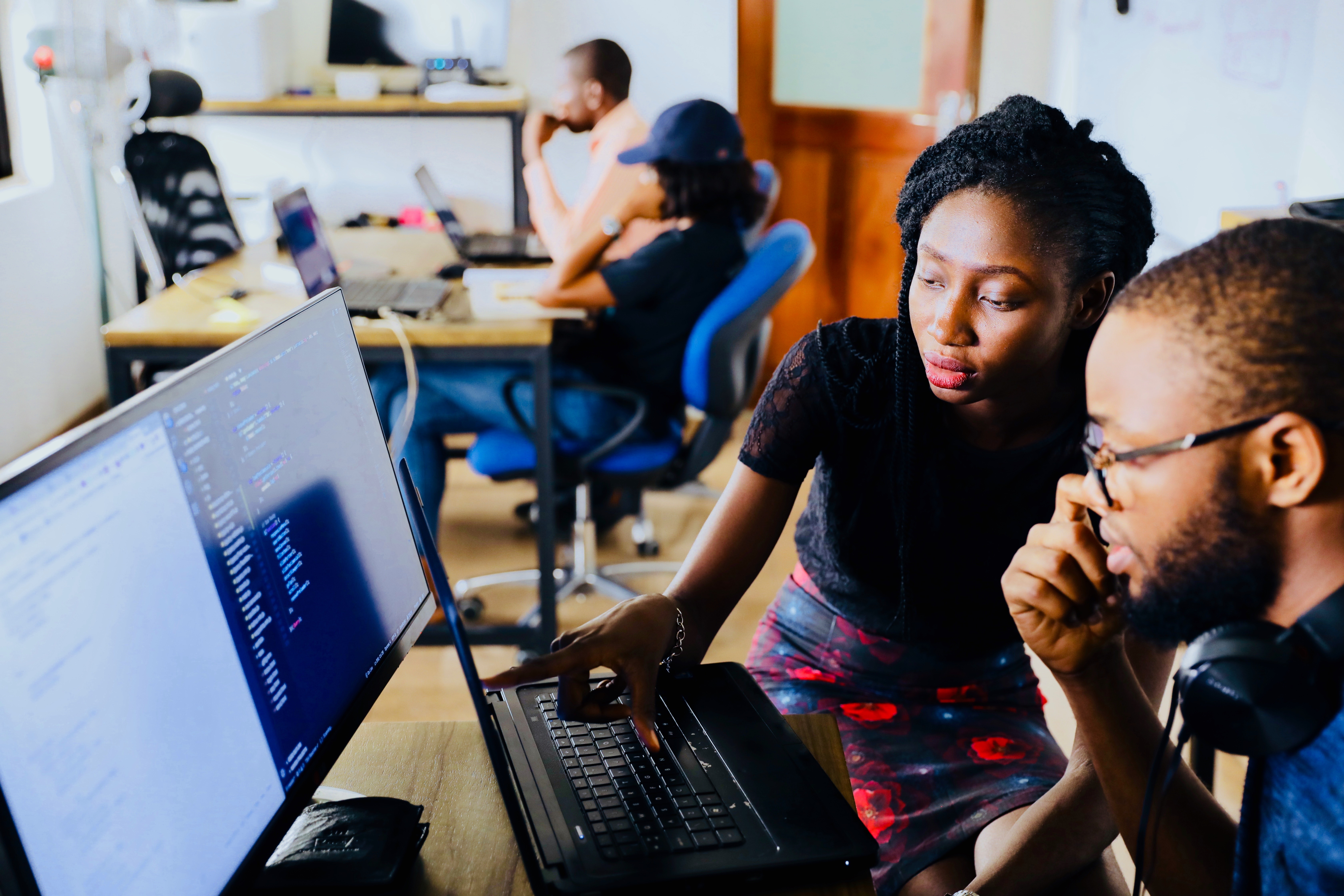 two web developers working at a desktop computer together