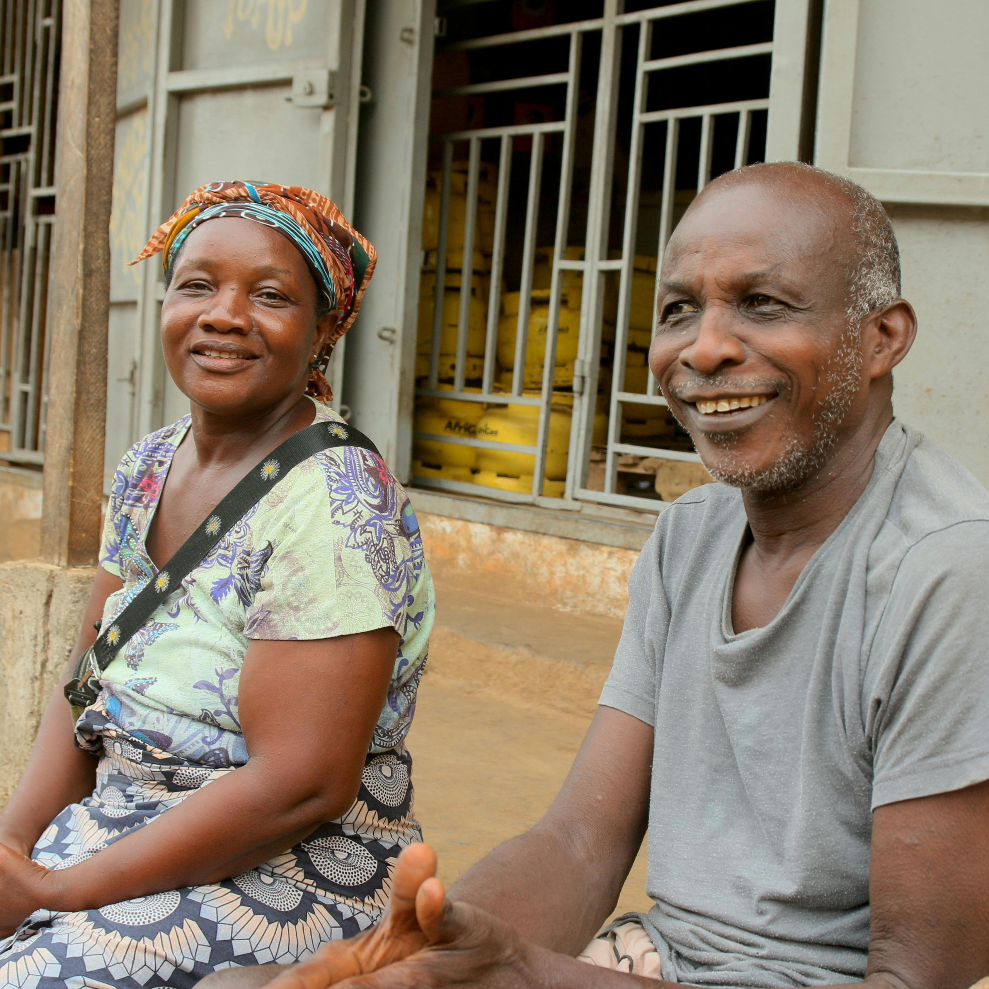 Elderly African couple sits on their patio.