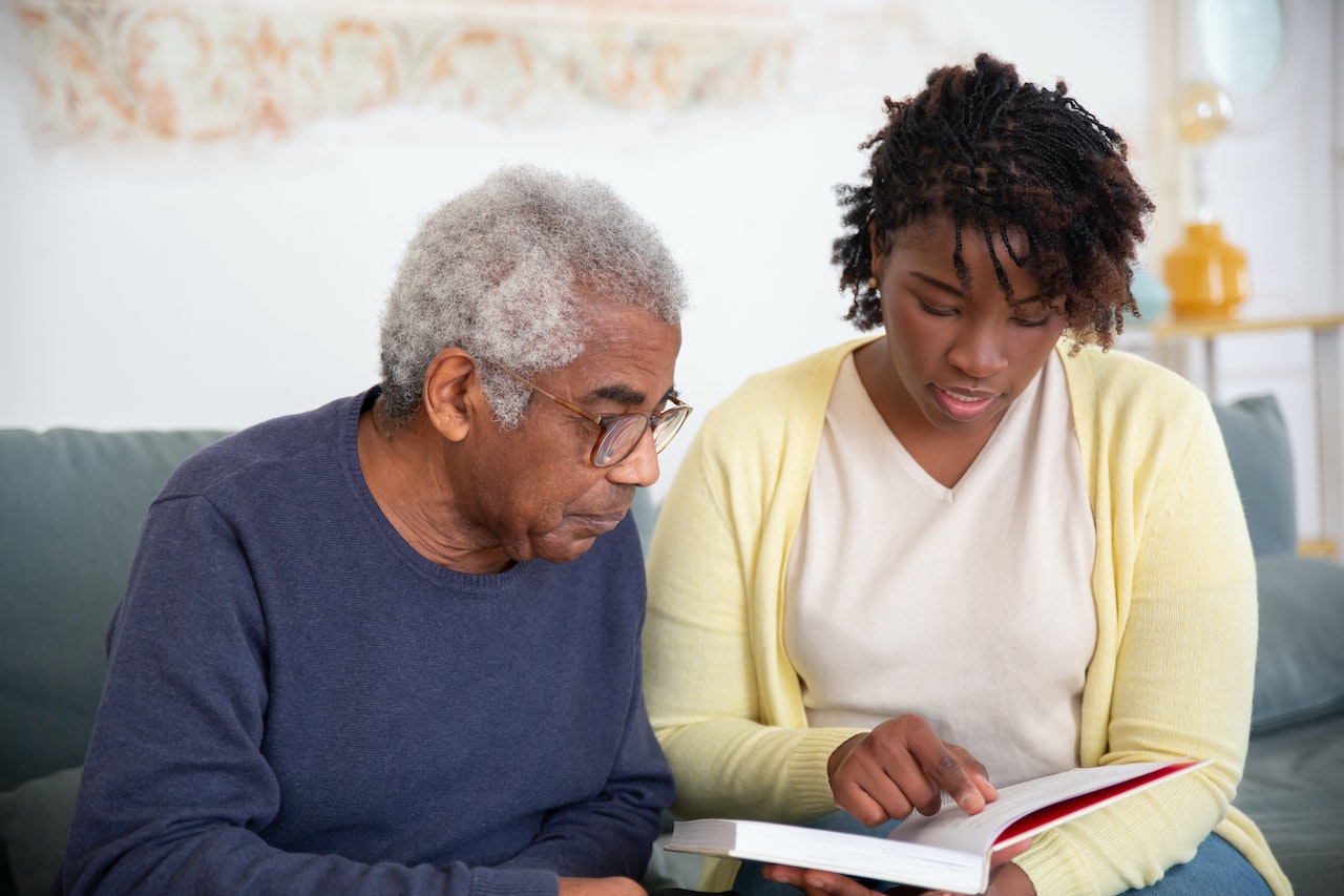 Elderly man with Nurse reading book