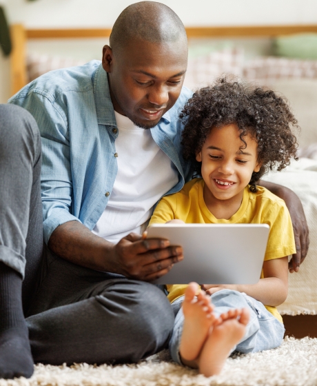 Father and son reading on tablet device